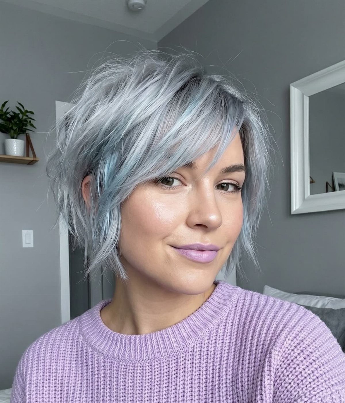 Woman with a short, tousled silver-gray shag haircut and side-swept bangs