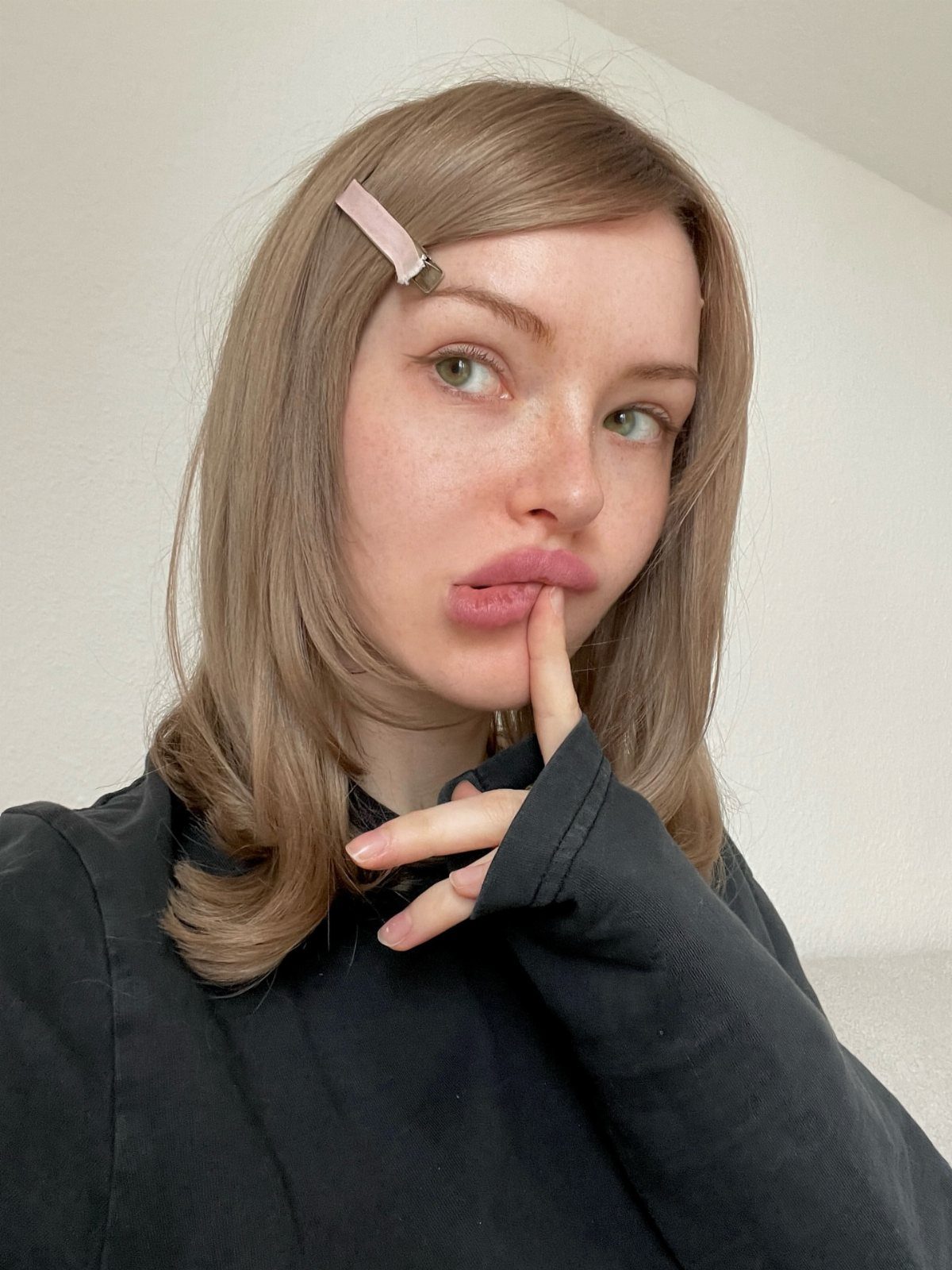 Woman displaying shoulder-length dark blonde hair with a pink clip
