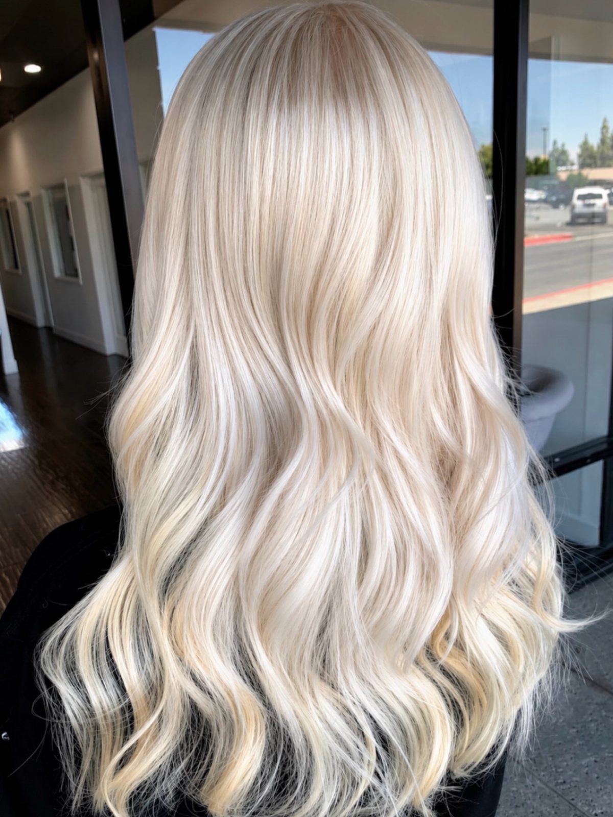 Long icy silver-blonde waves with cool ash-toned strands shown from behind