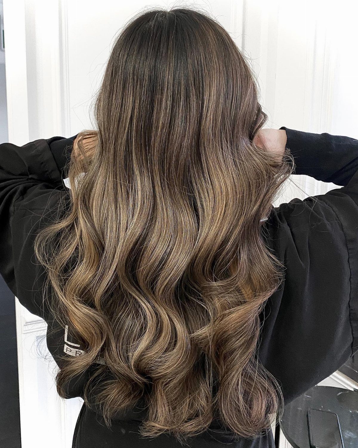 Long wavy brown hair with dimensional blonde balayage highlights