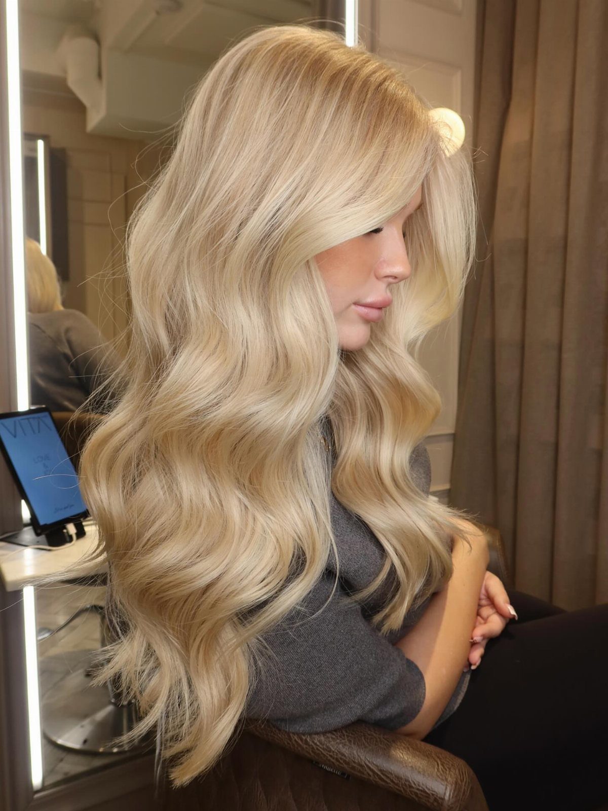 Woman with long wavy icy blonde hair blended with warm golden tones