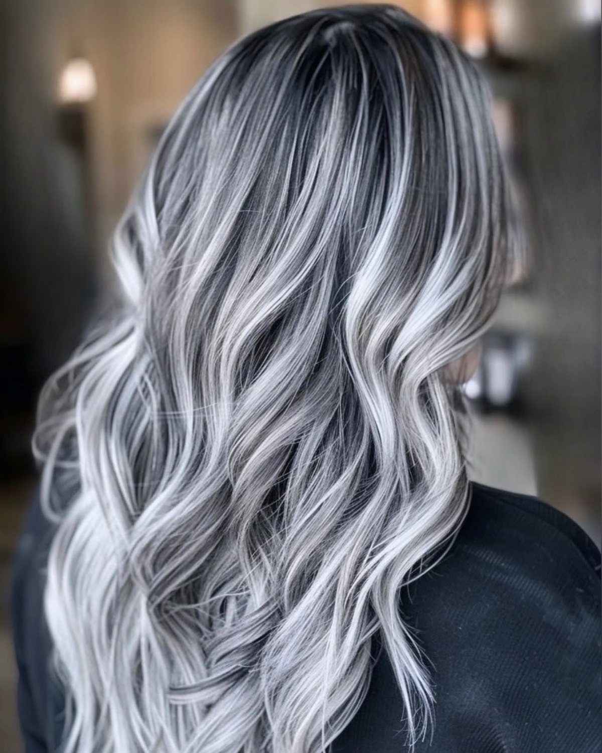 Silver-platinum waves with dark root shadow cascade down the back