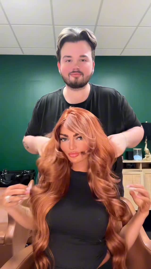 Woman with long copper-red hair seated in a salon chair