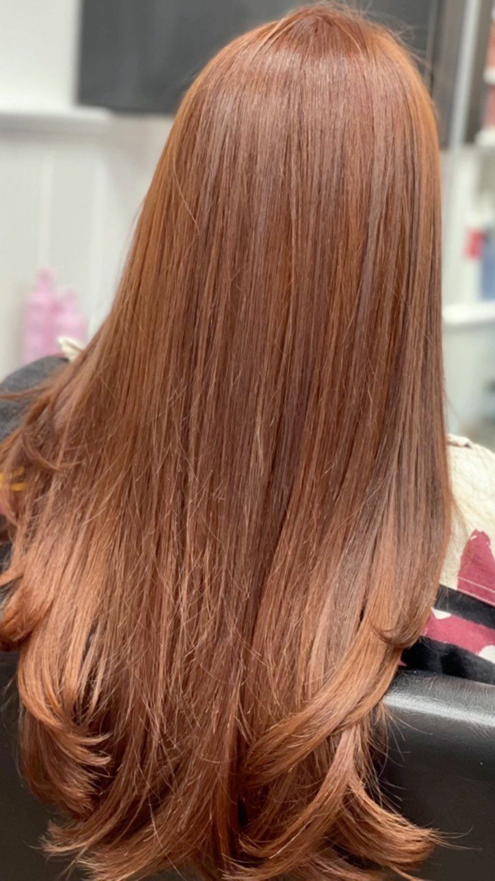 Reddish-brown hair with copper tones and curled ends shown from behind