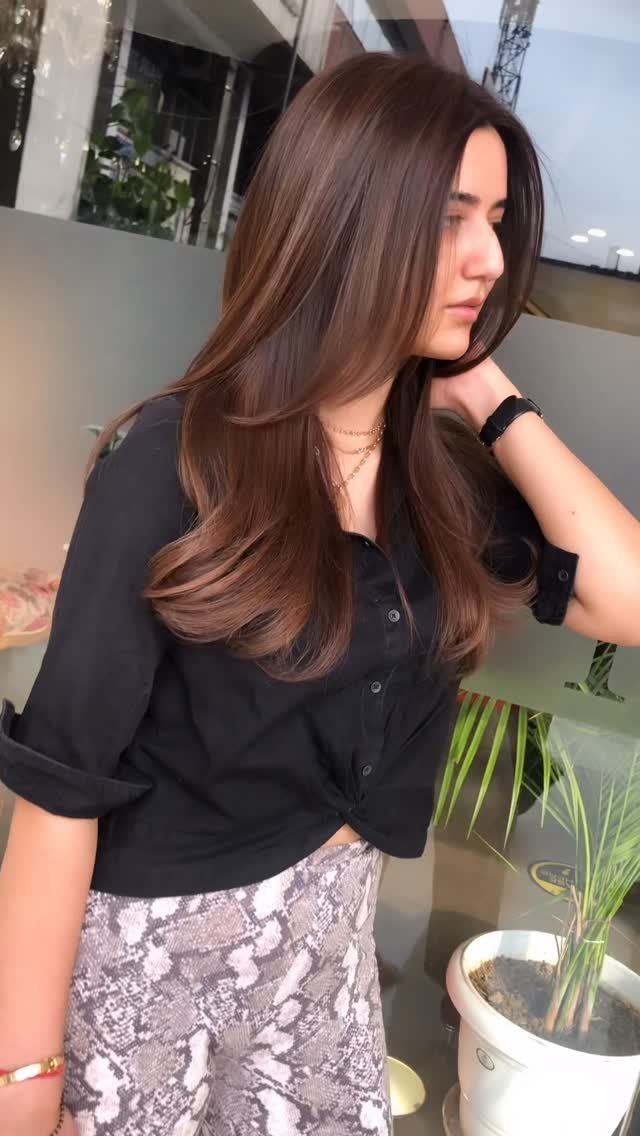 Woman with long warm brown hair and softly curled ends