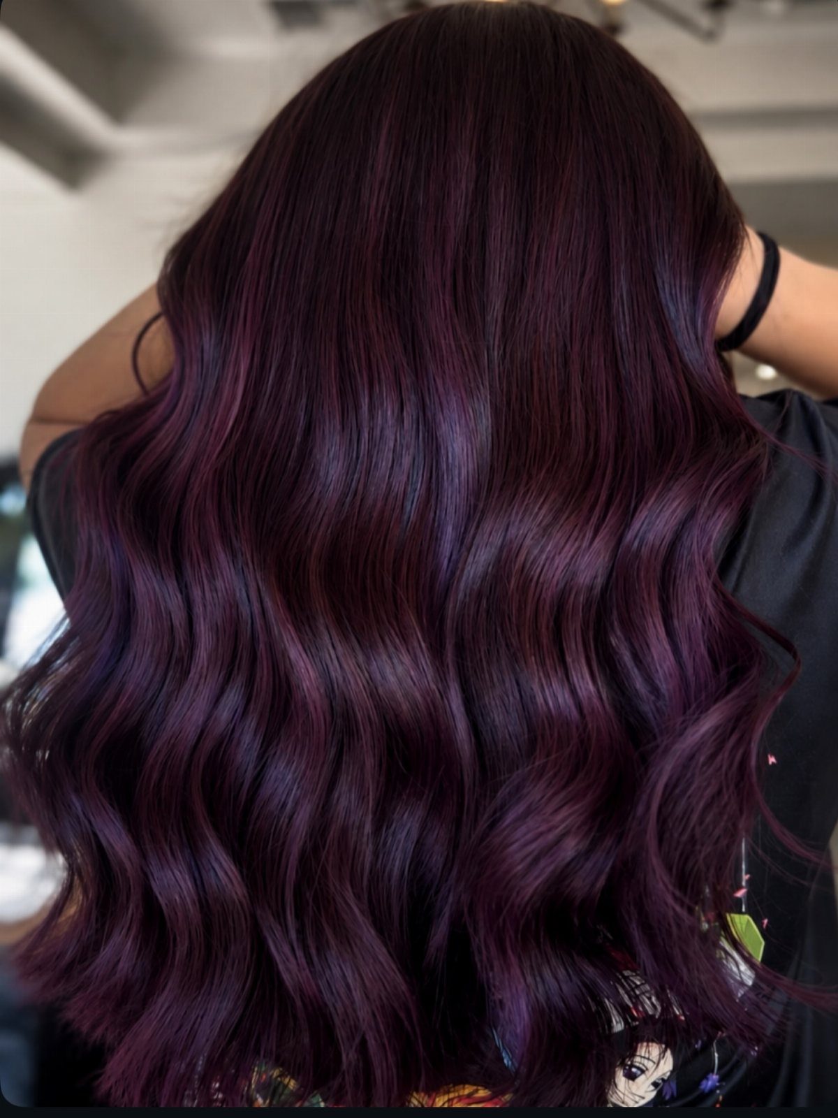 Long wavy dark hair with glossy plum-purple color throughout the lengths