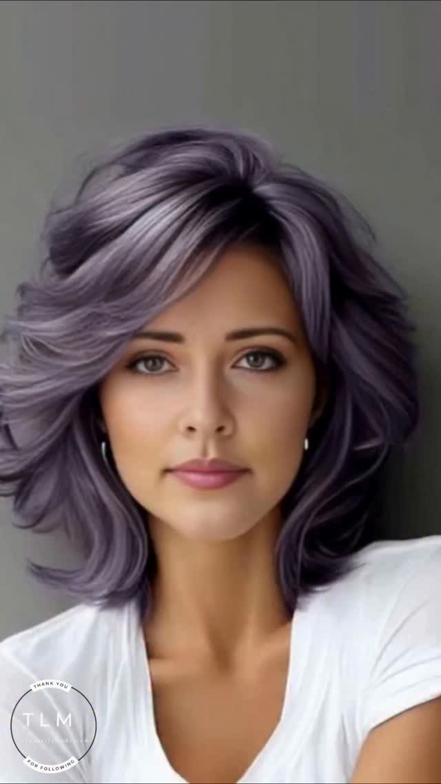 Woman with voluminous lavender-plum hair, side part, and long swept bangs