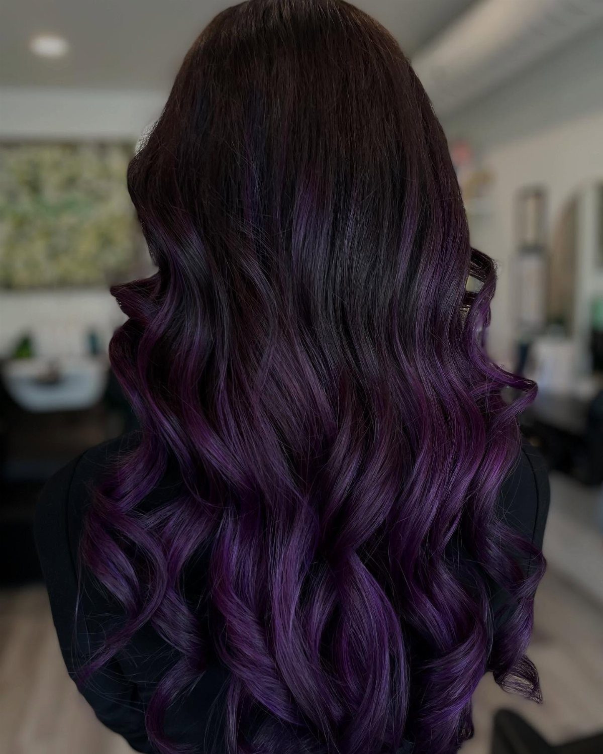Long dark hair transitions into glossy plum-purple curls at the ends