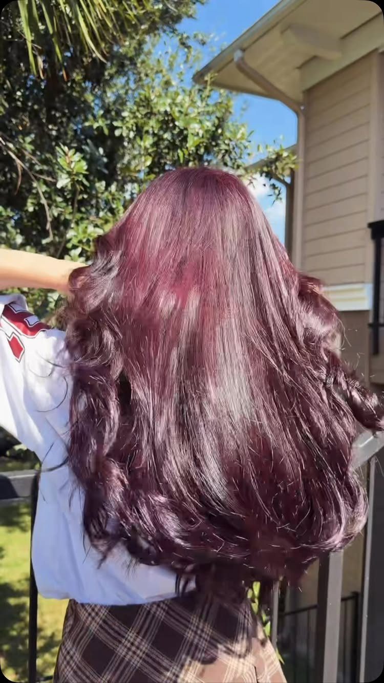 Long, wavy violet hair shown from behind outdoors in sunlight
