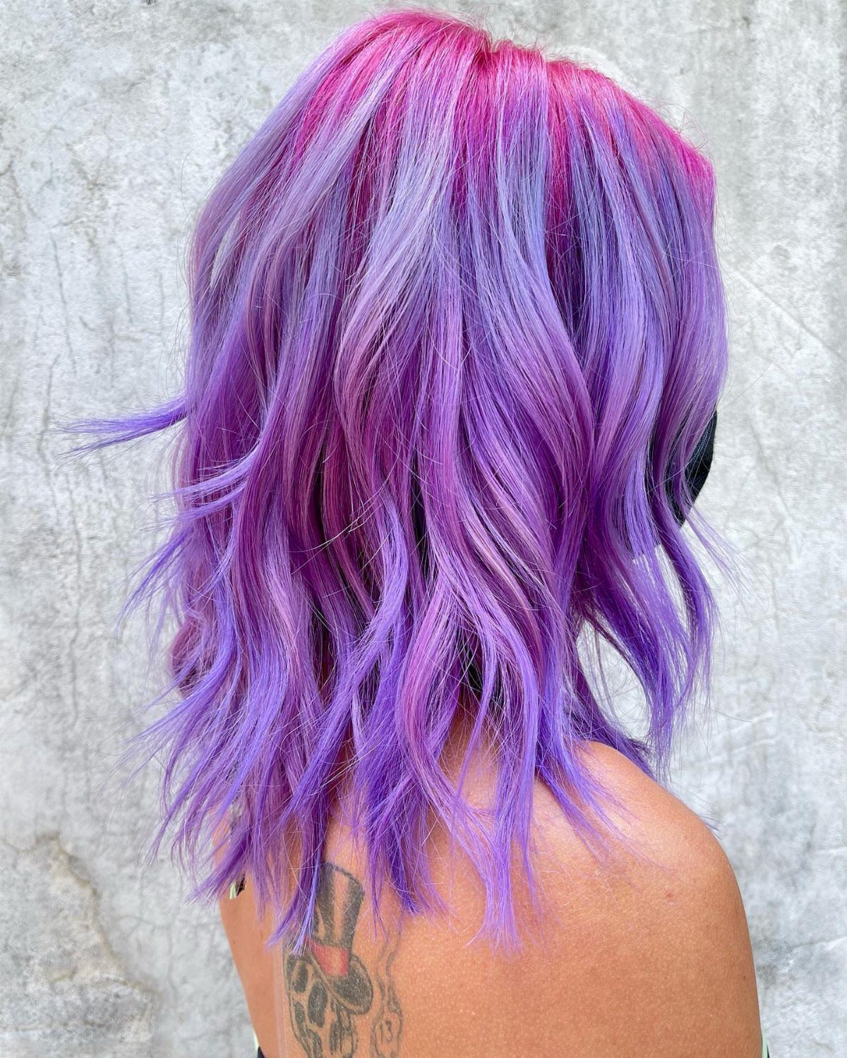 Wavy lavender and deep purple hair with pink tones near the crown