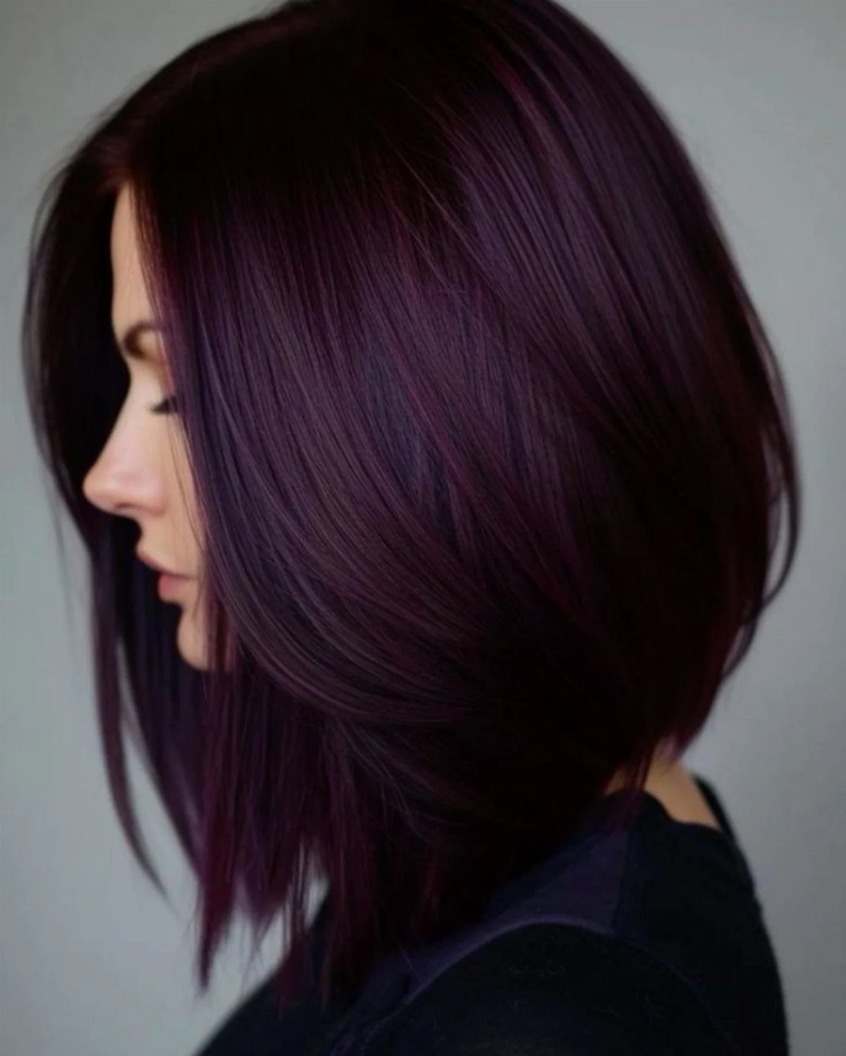 Woman with a layered bob in saturated dark burgundy-purple hair