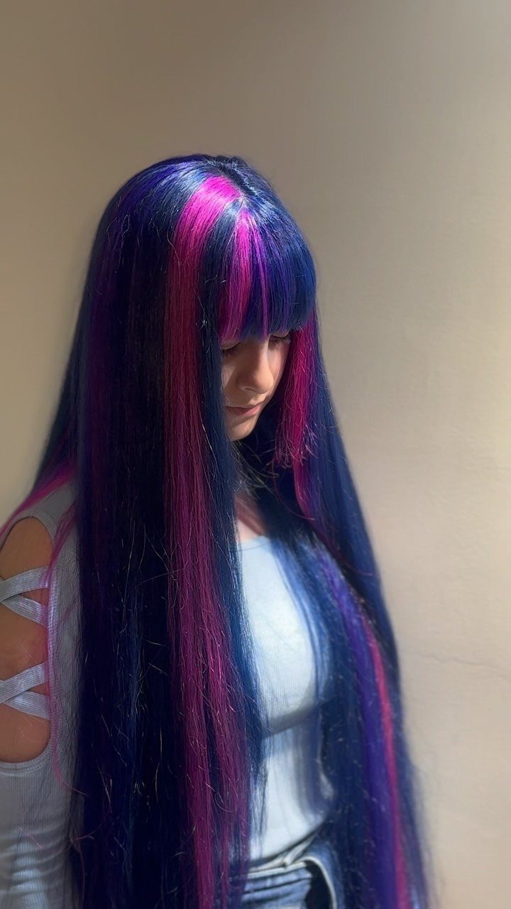Long dark blue hair with vivid purple and pink streaks and blunt bangs