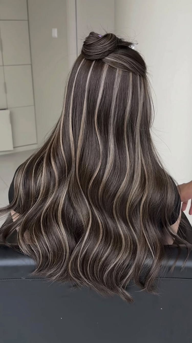 Long dark waves with broad, blended blonde ribbons through the hair