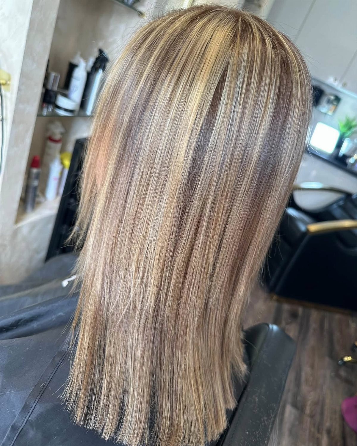 Highlighted straight hair shows fine blonde streaks throughout a light brown base