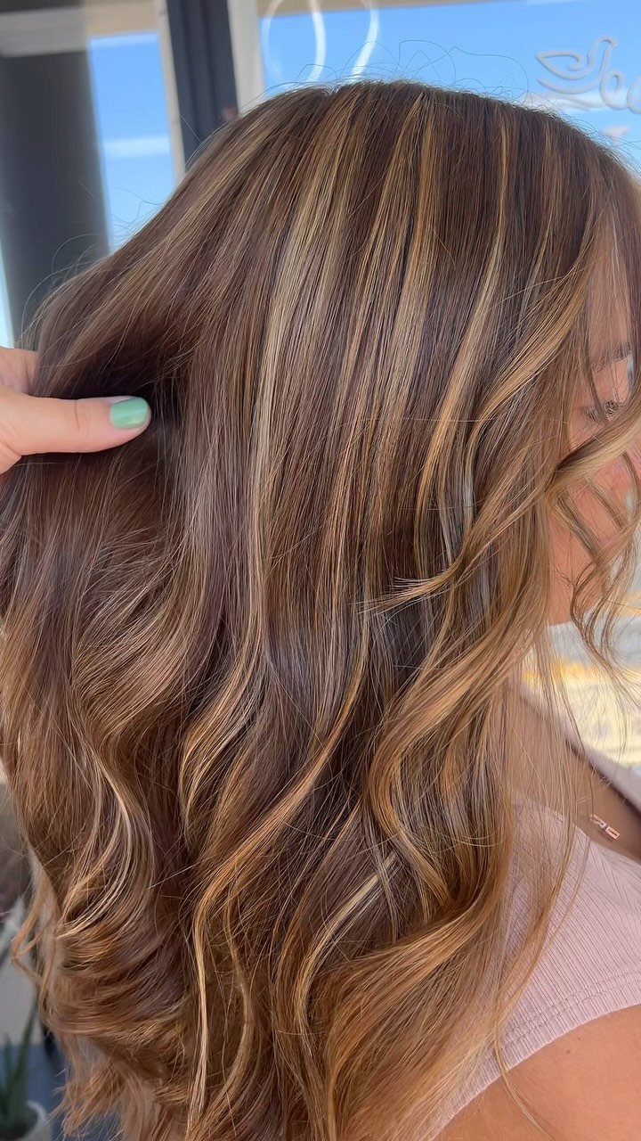 Wavy brown hair with blonde highlights concentrated in sections