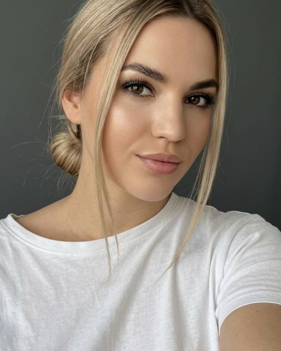 Woman with champagne-blonde hair and face-framing strands wearing a white shirt
