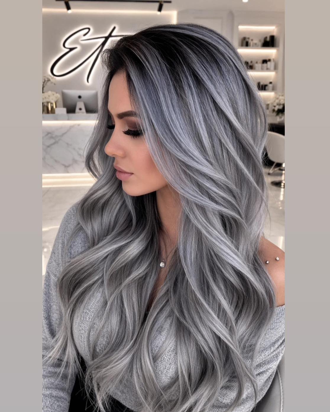 Woman with long, wavy silver-gray hair posing in a salon