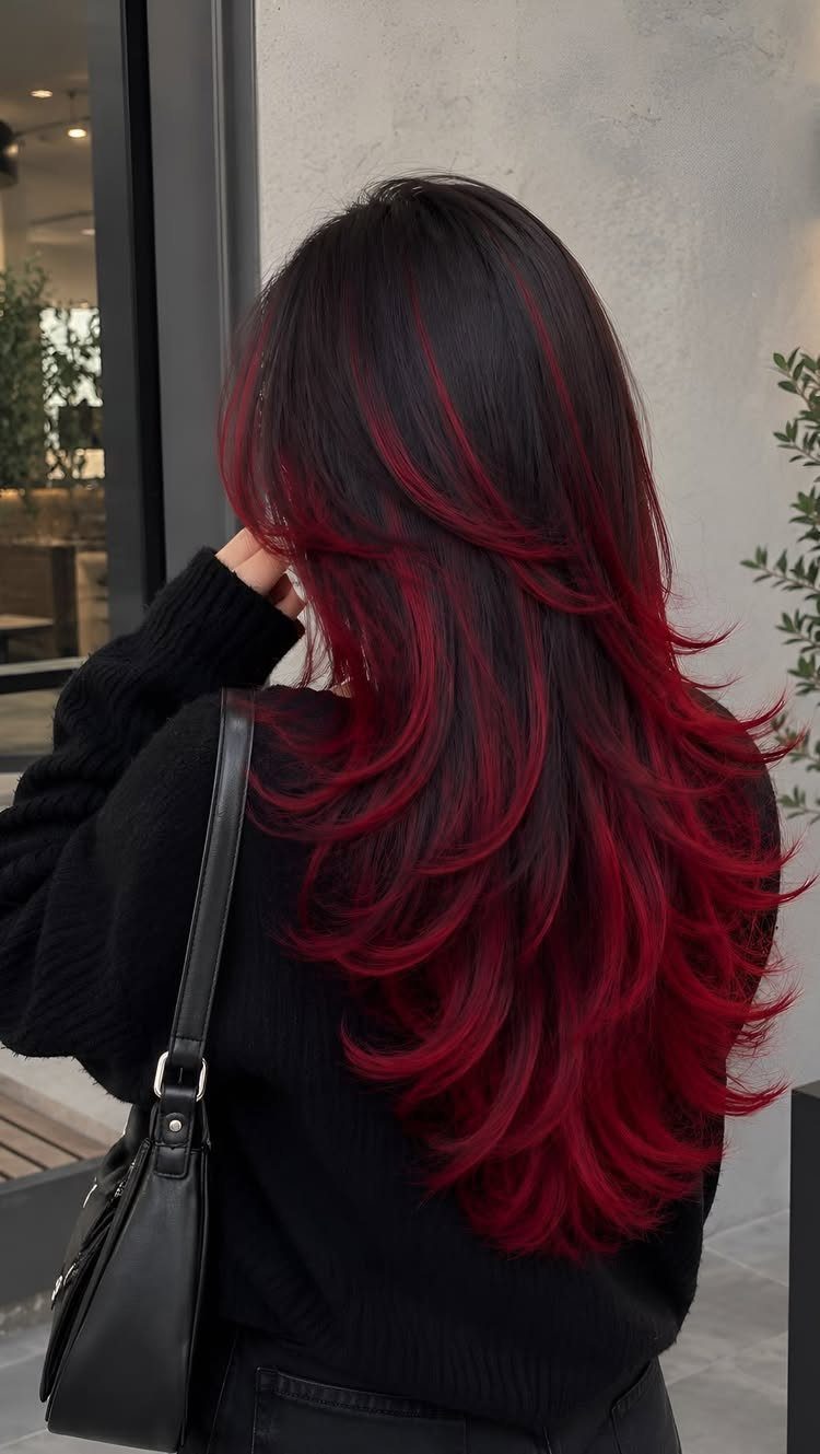 Long dark layered hair with vivid red highlights and red ends