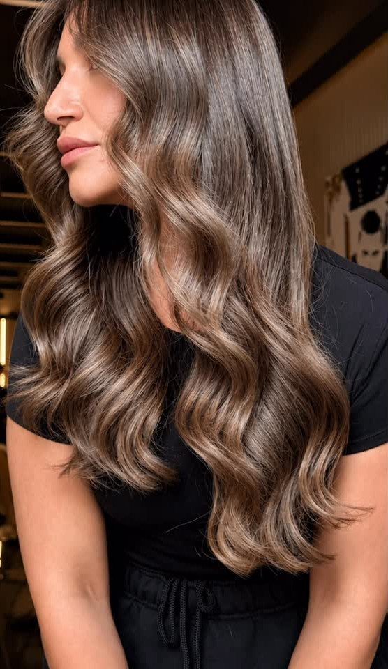 Woman with long, wavy light brown hair shown in profile