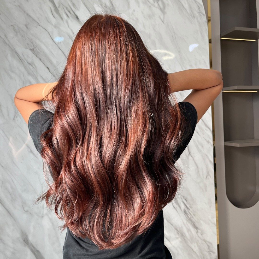 Long wavy reddish-brown hair with glossy red tones shown from behind