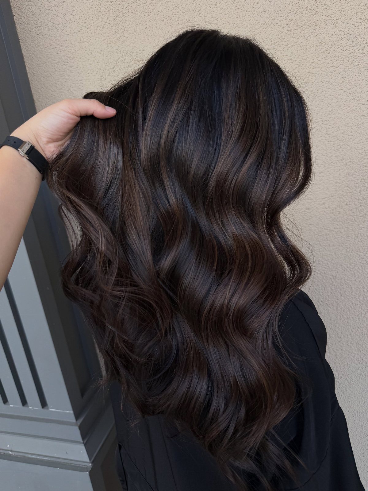 Long, wavy charcoal brunette hair with subtle cool-toned highlights
