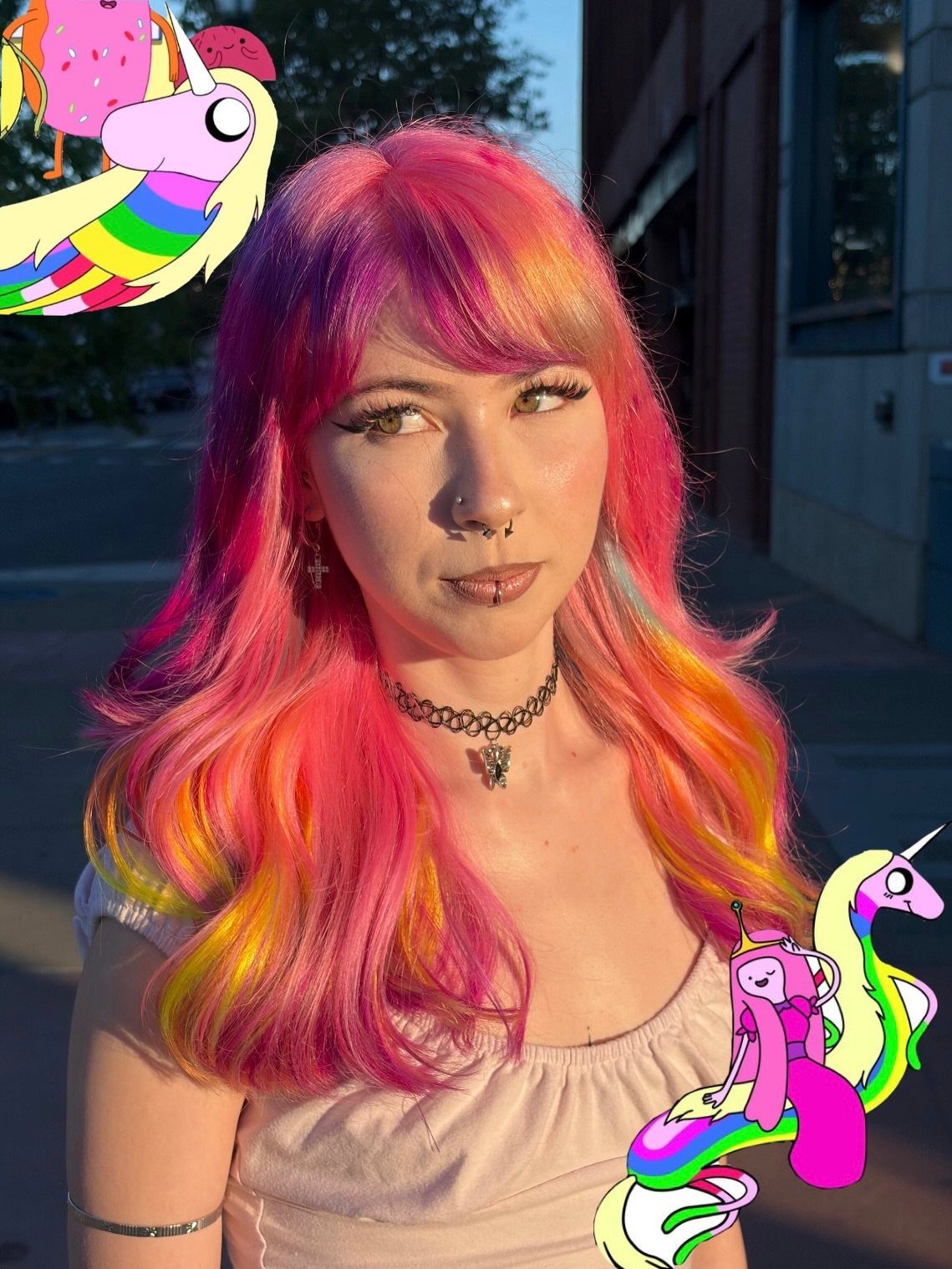Woman with long vivid pink hair accented by orange, yellow, and purple strands