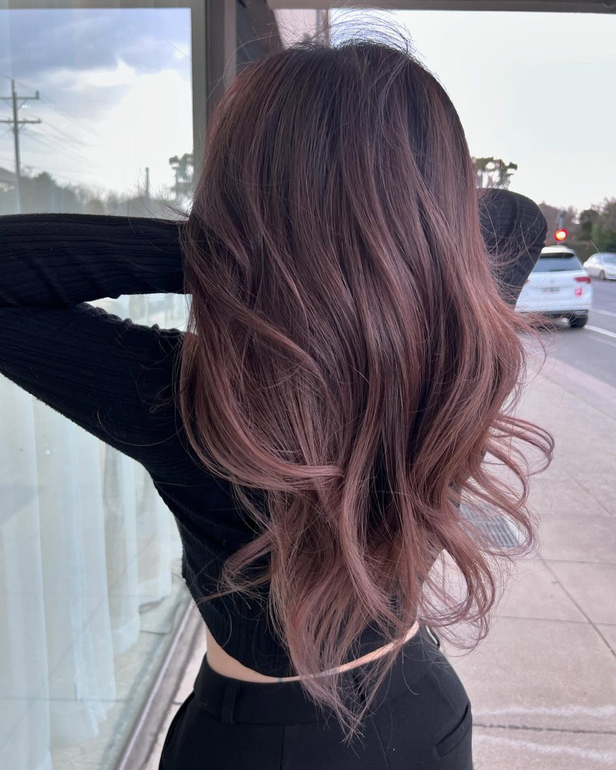 Long wavy dusty mauve hair with darker roots shown from behind