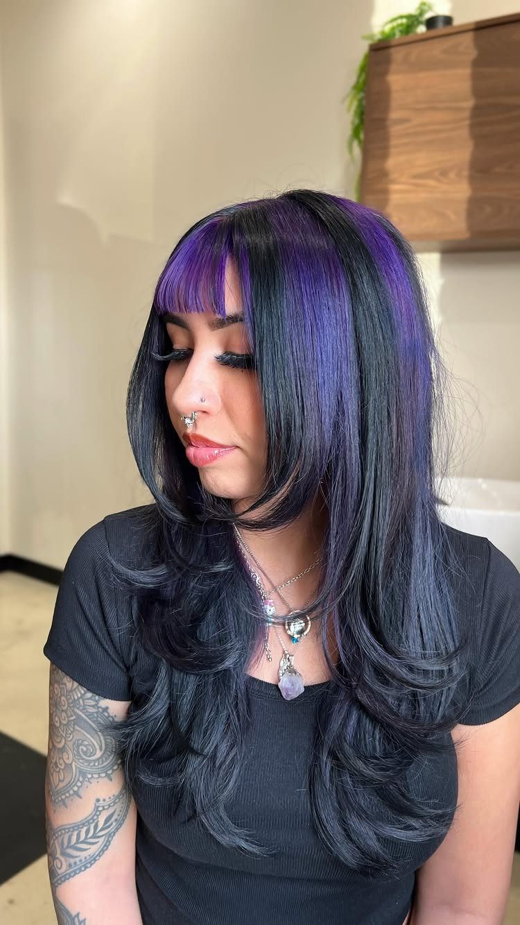 Woman with long black hair and vivid purple bangs and front streaks