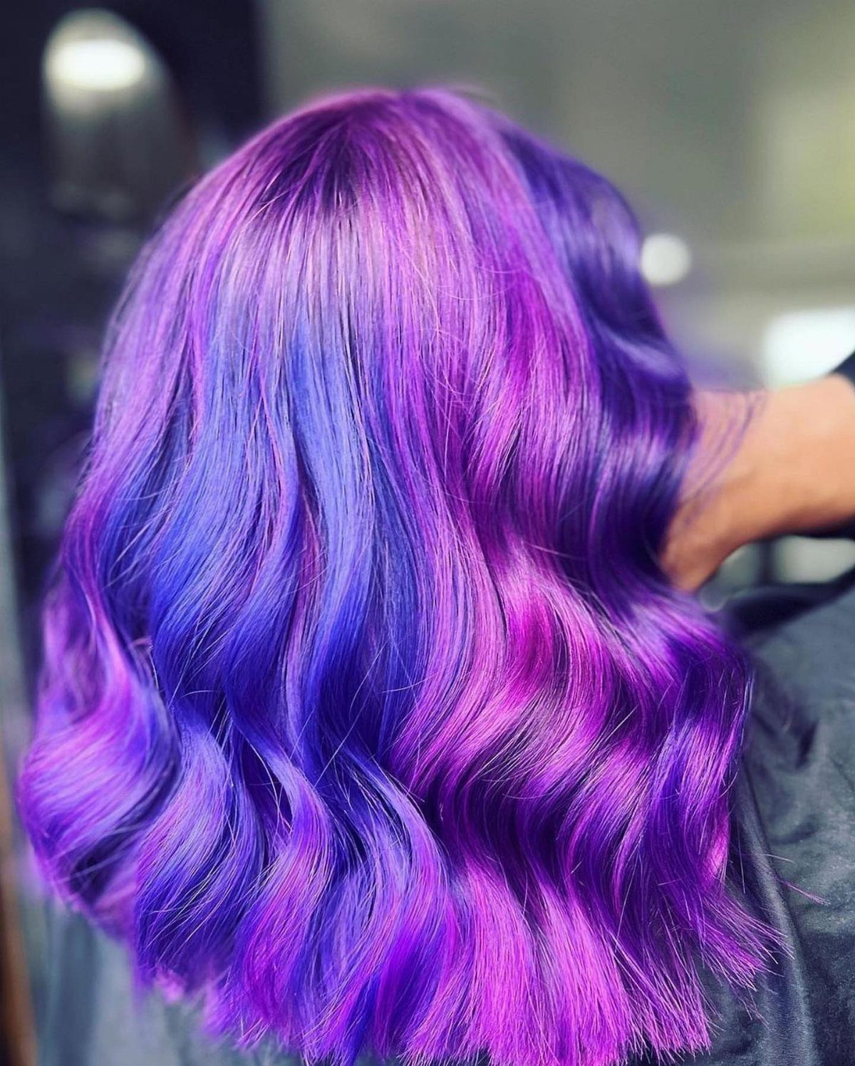 Wavy hair with vivid purple and pink-purple coloring in a salon