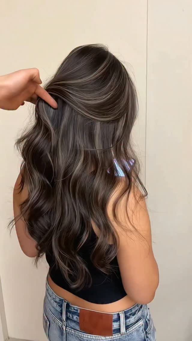 Long wavy dark hair with cool smoky gray-brown highlights shown from behind