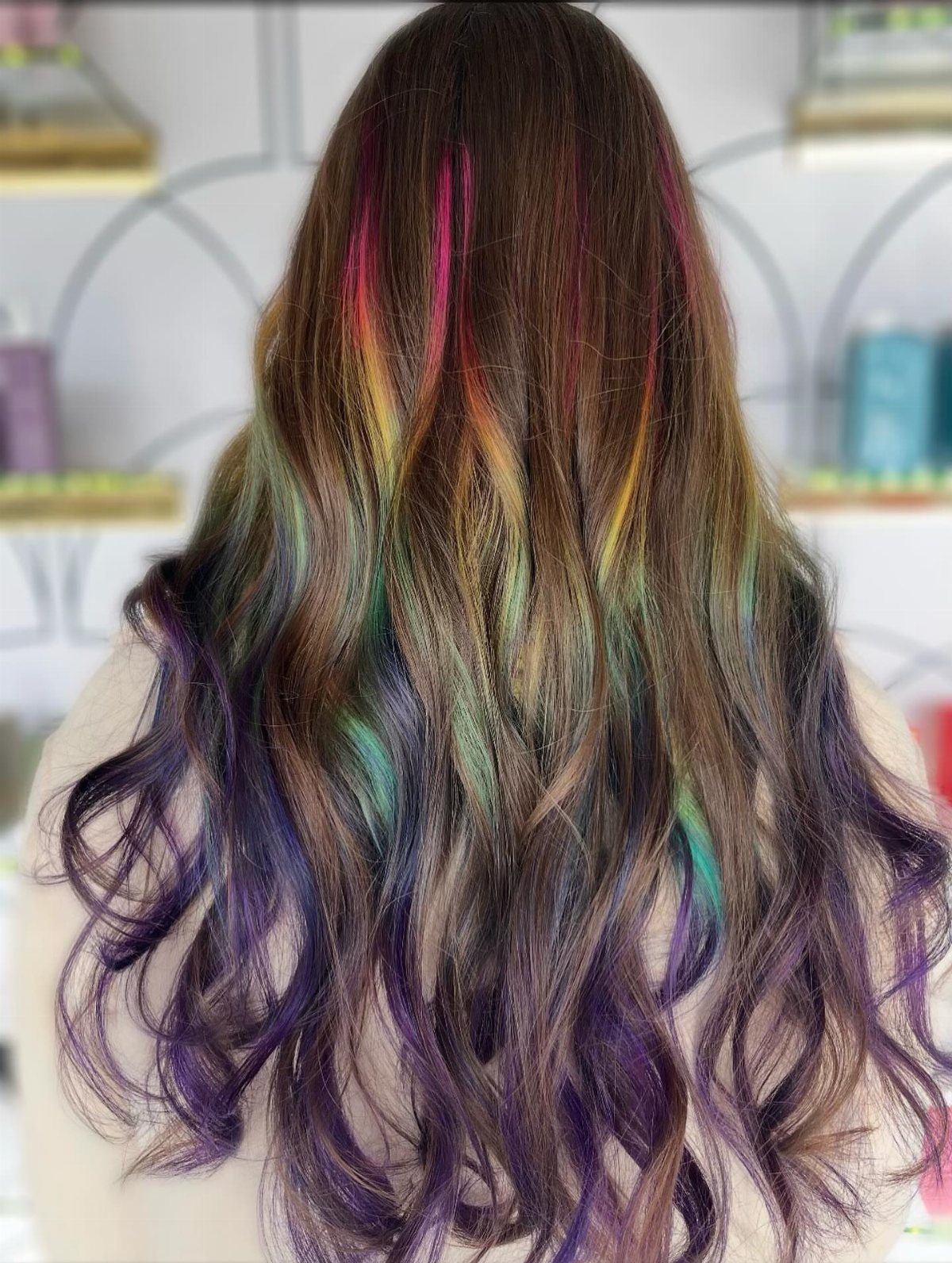 Long dark wavy hair with scattered teal, violet, pink, and blonde streaks