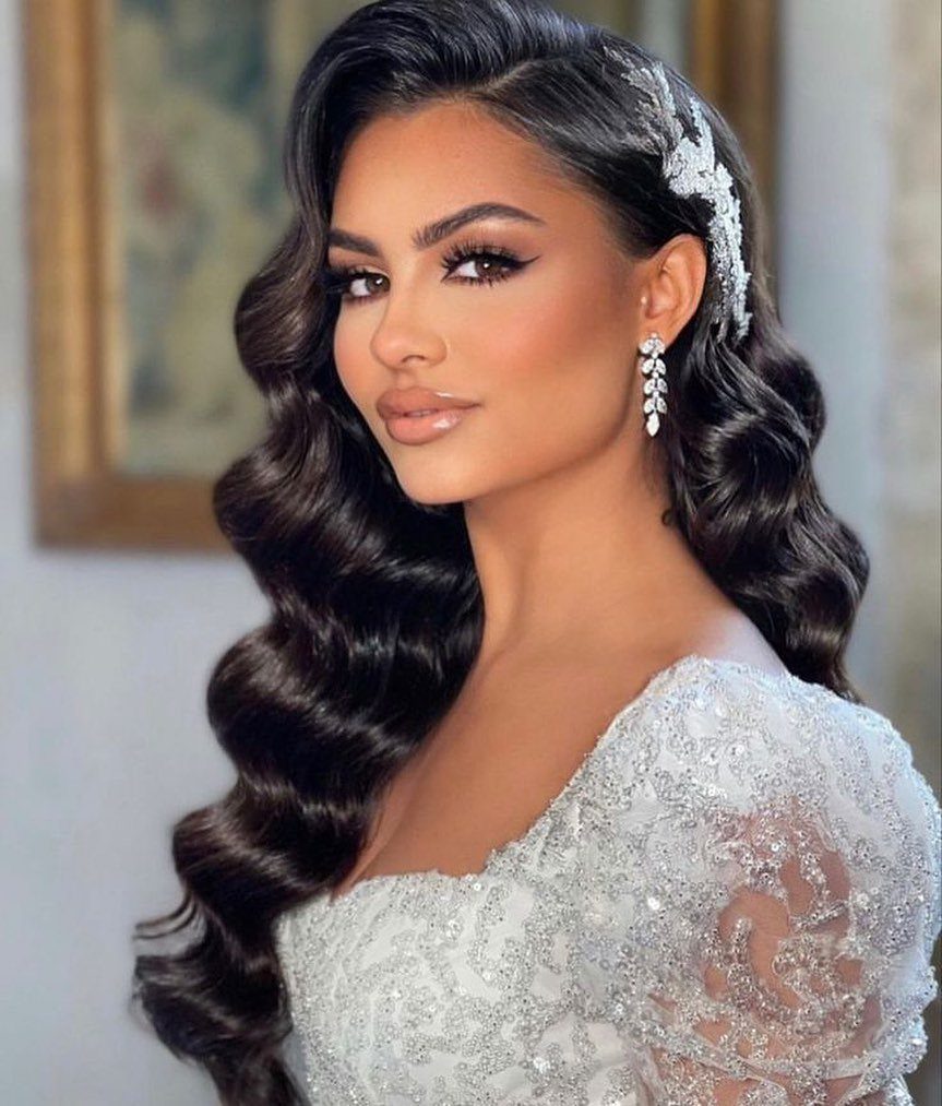 Woman with glossy, defined Hollywood waves swept over one shoulder