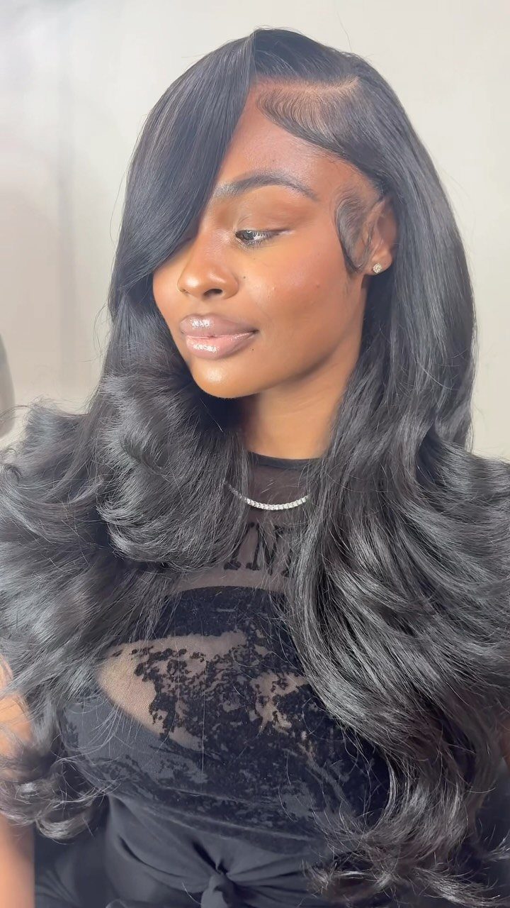 Woman wearing long, glossy black hair styled in soft defined curls