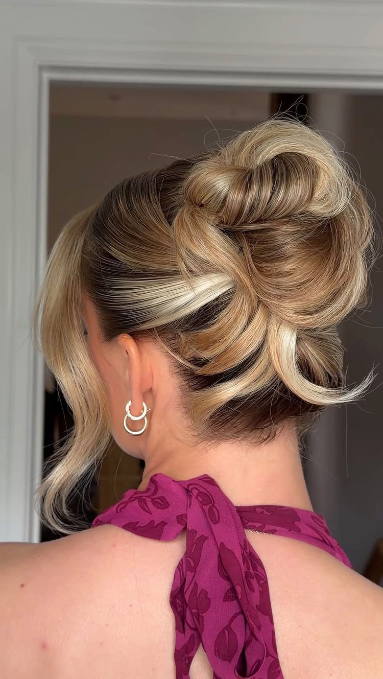 Blonde twisted updo with loose curls pinned high at the back