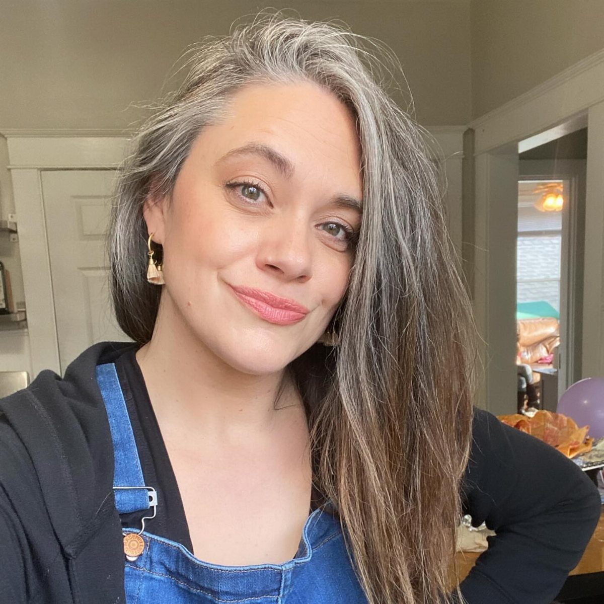 Woman showing long brown hair with gray face-framing wisps
