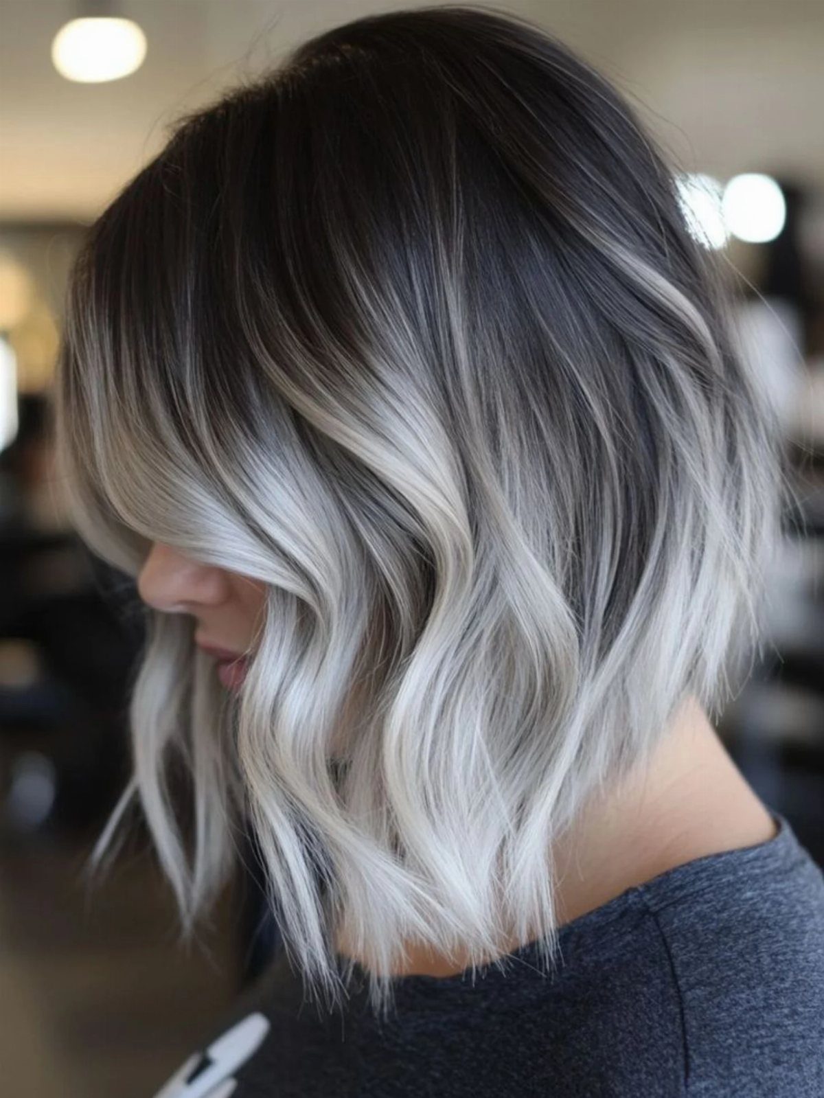 Layered silver-gray bob with dark roots and soft waves