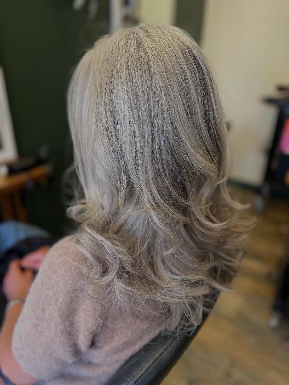 Layered silver-gray haircut with long feathered waves, shown from behind