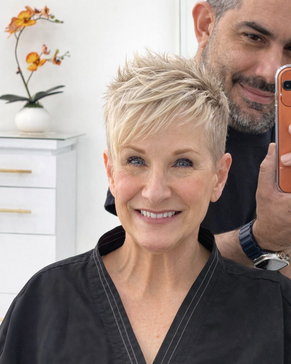 Older woman models a short textured blonde pixie cut in a salon