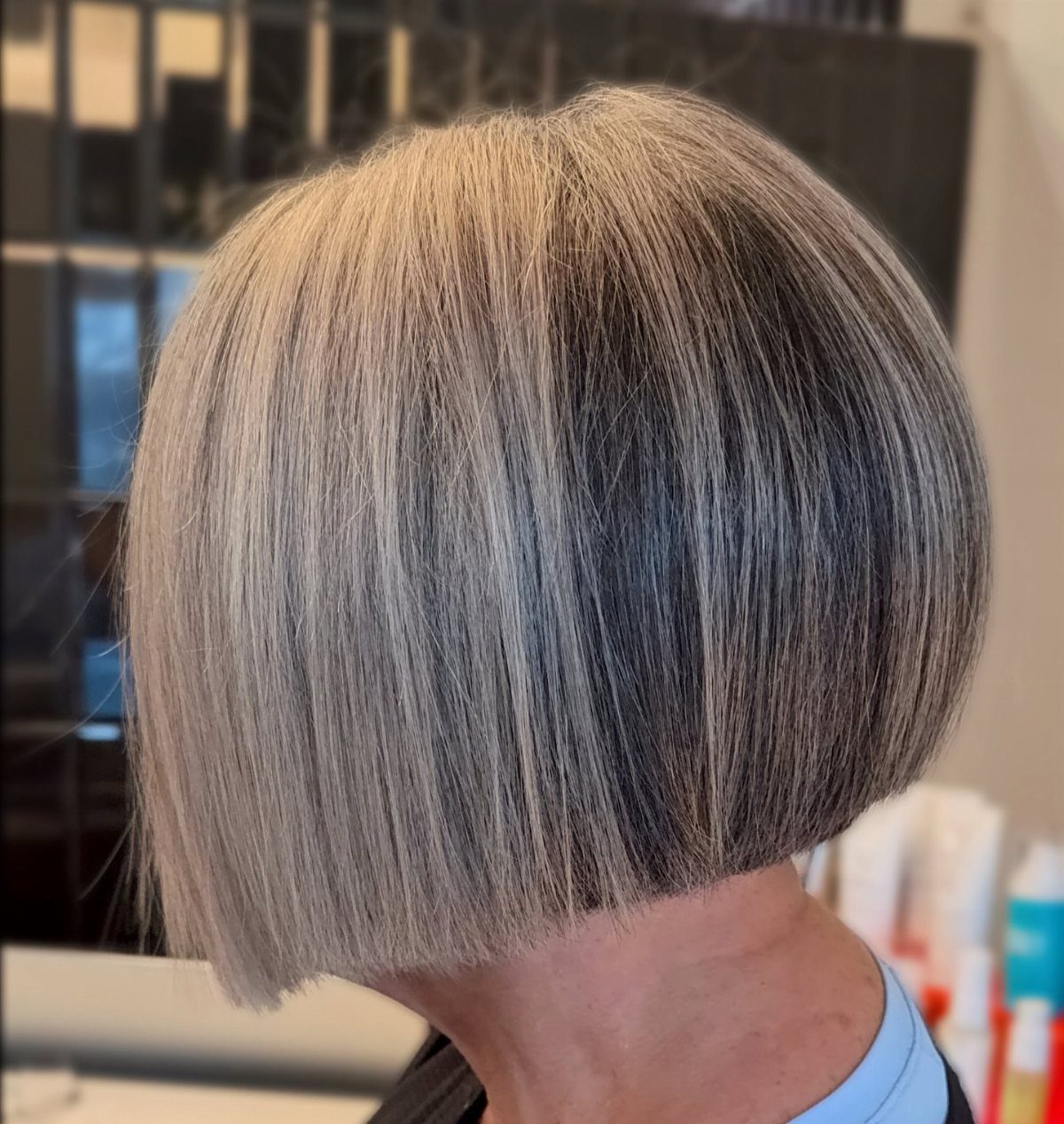 Silver-gray blunt bob shown from behind in a salon