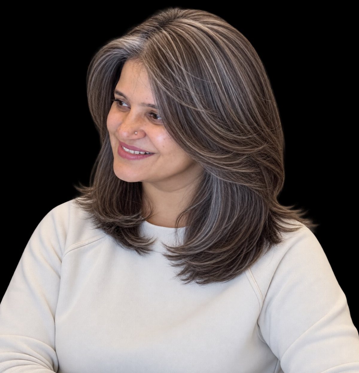Woman with layered brown hair and silver strands framing her face