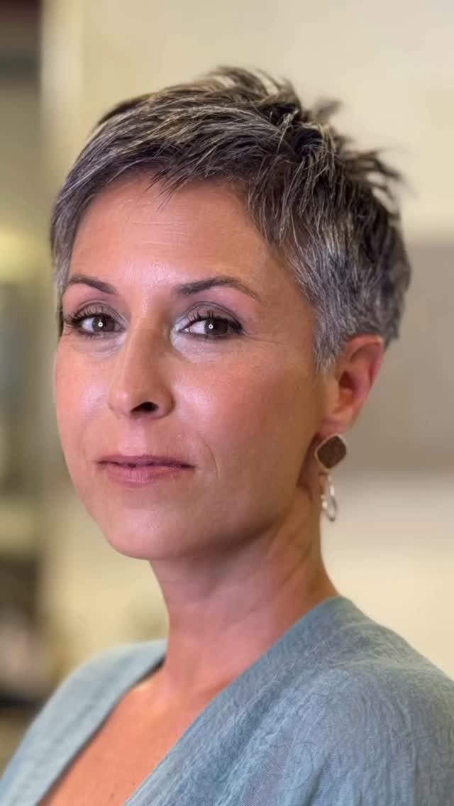Woman with a short textured gray pixie cut and longer tousled hair on top