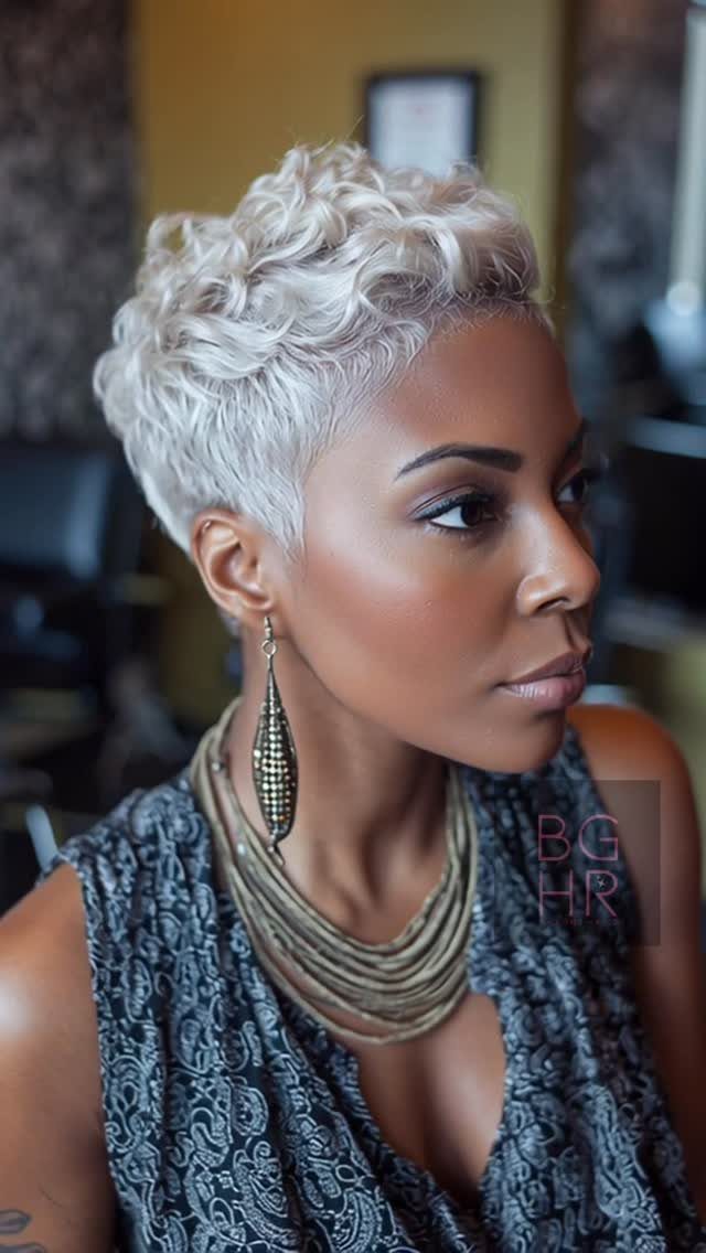 Woman wearing a short, textured silver crop with tapered sides and curls.