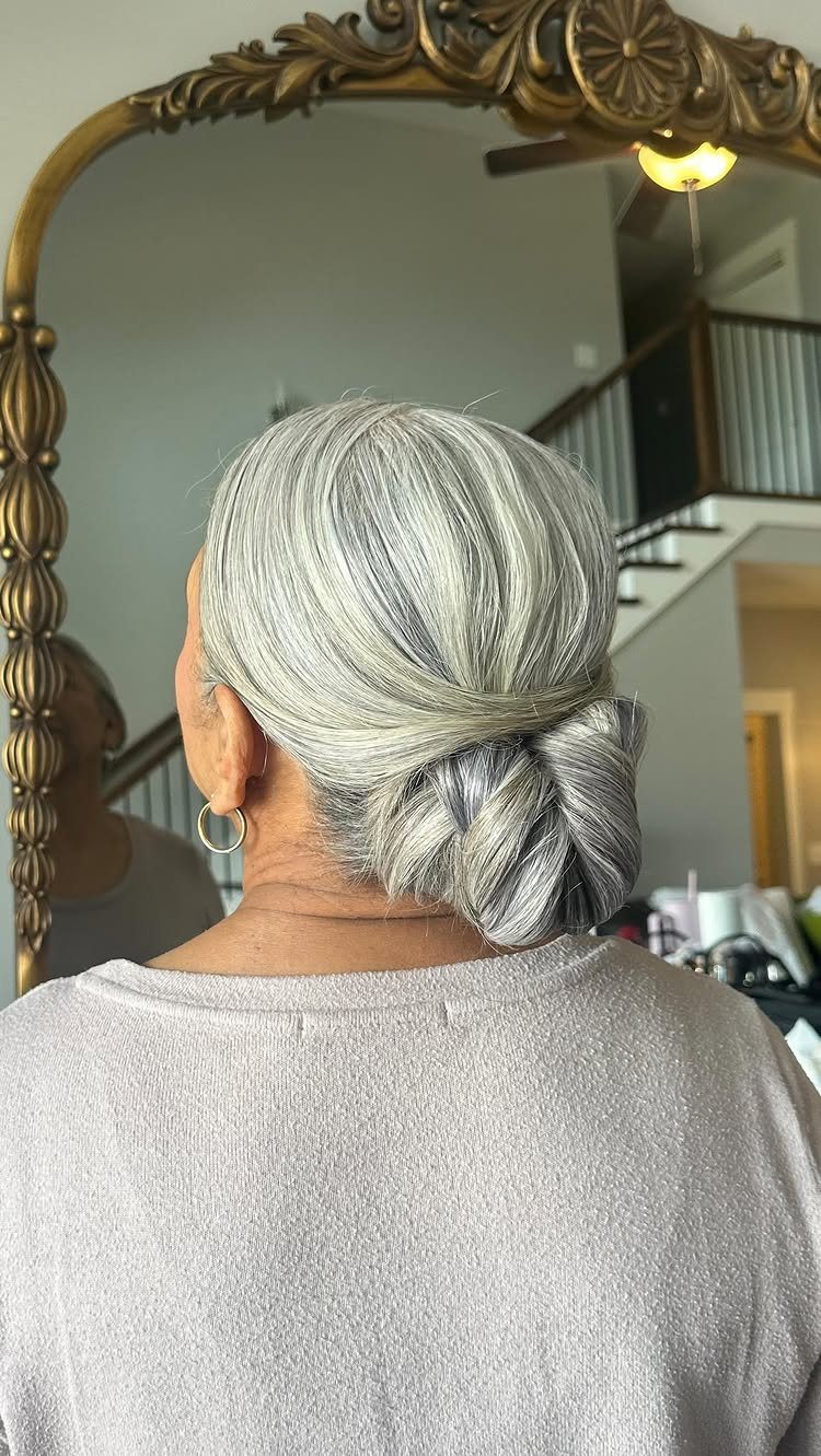 Silver-gray hair swept back into a low loose bun, viewed from behind