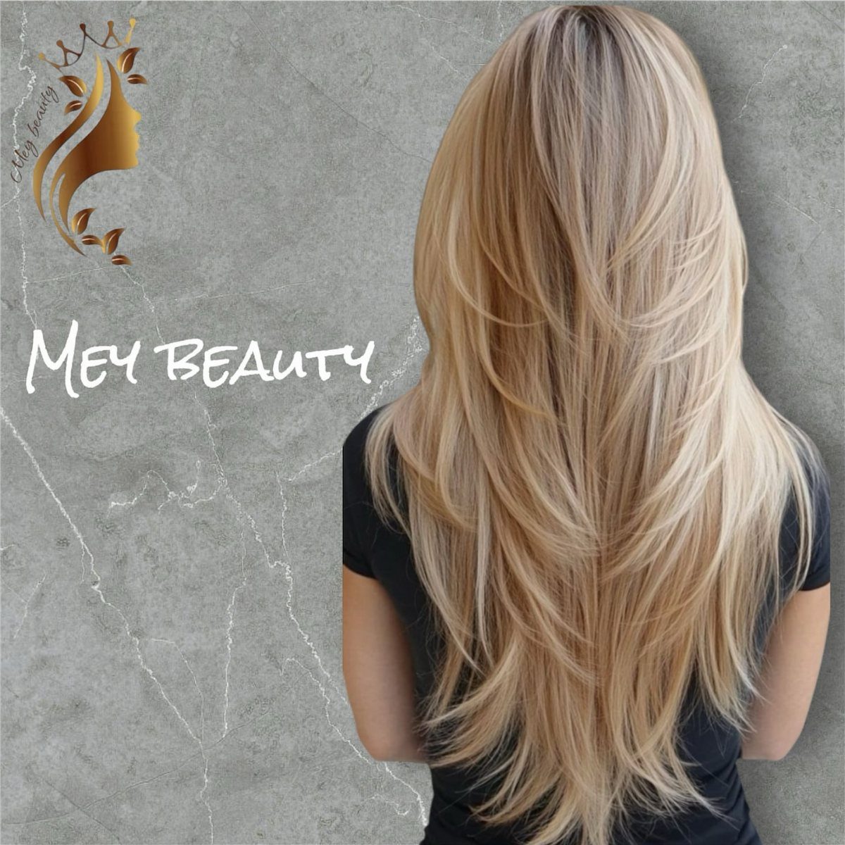 Long blonde layered hair falls down a woman’s back against a gray wall