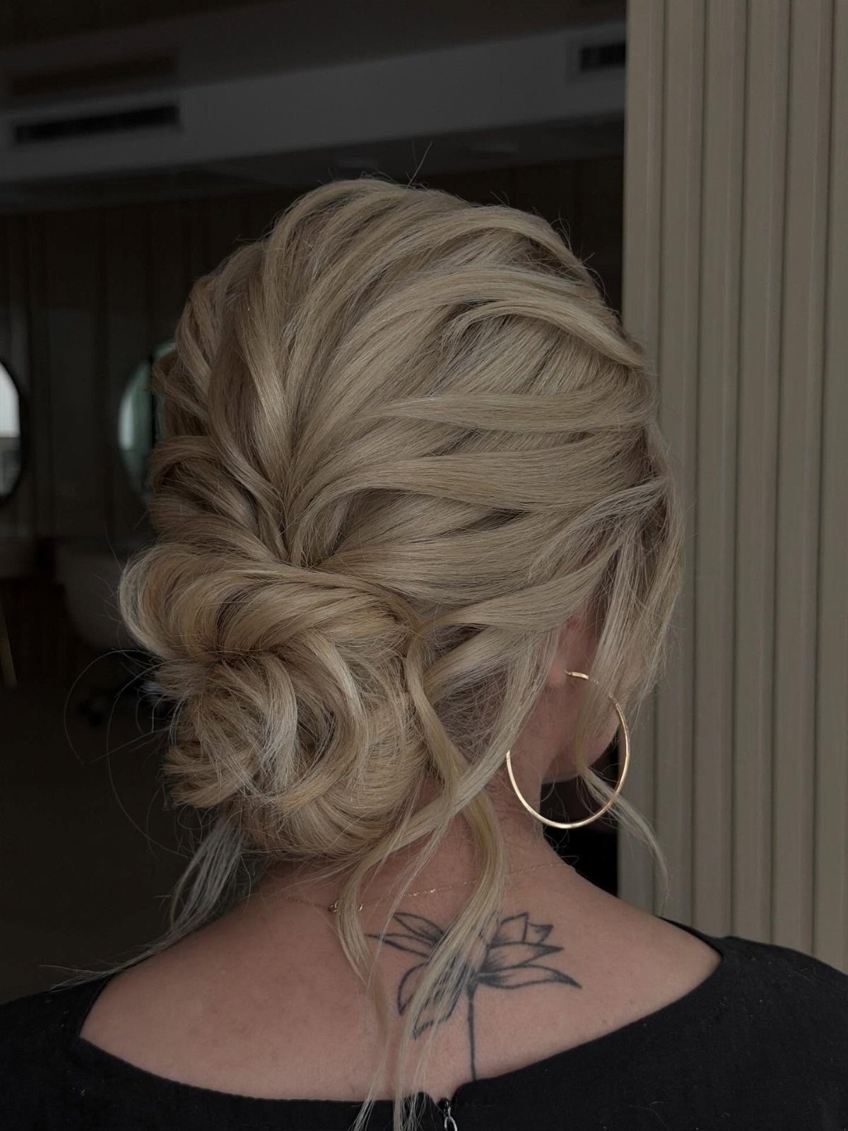 Blonde textured chignon with a loose low bun and wispy strands