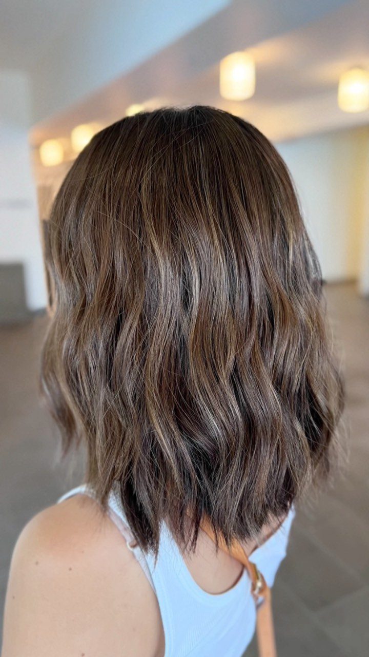 Wavy highlighted shoulder-length bob viewed from behind in a salon