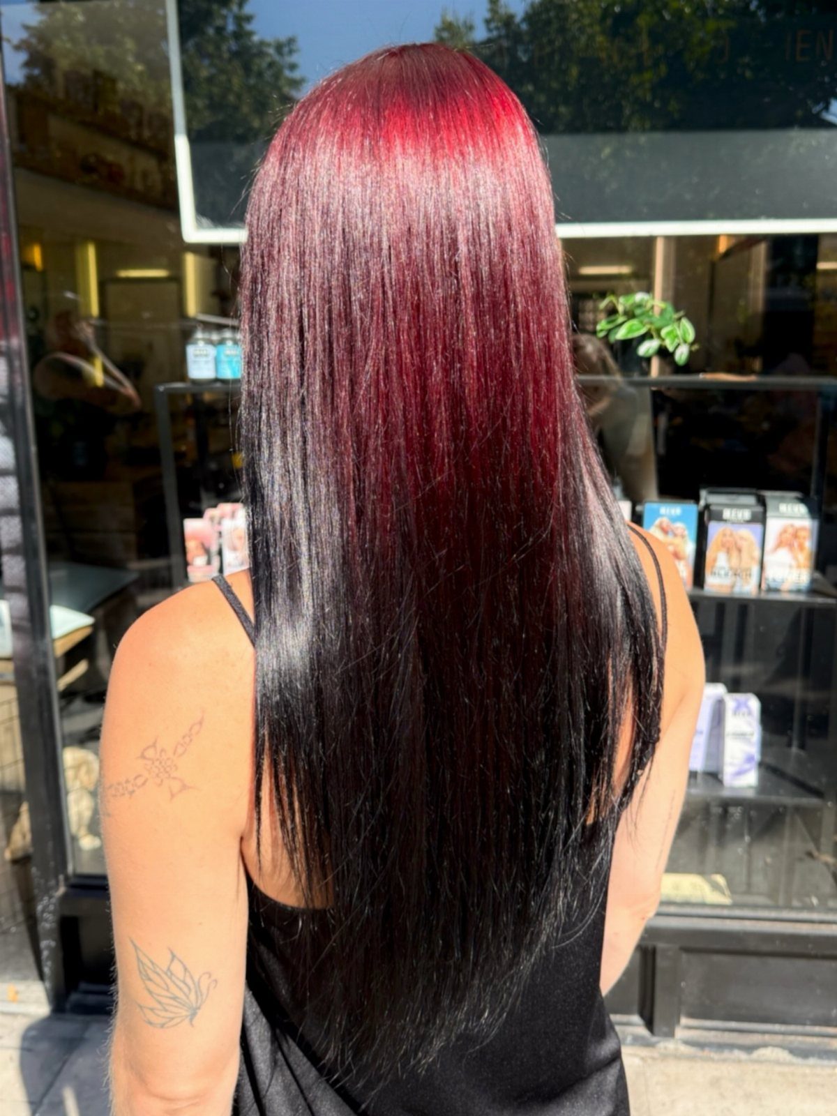 Long glossy hair fades from vivid red to dark burgundy and black.