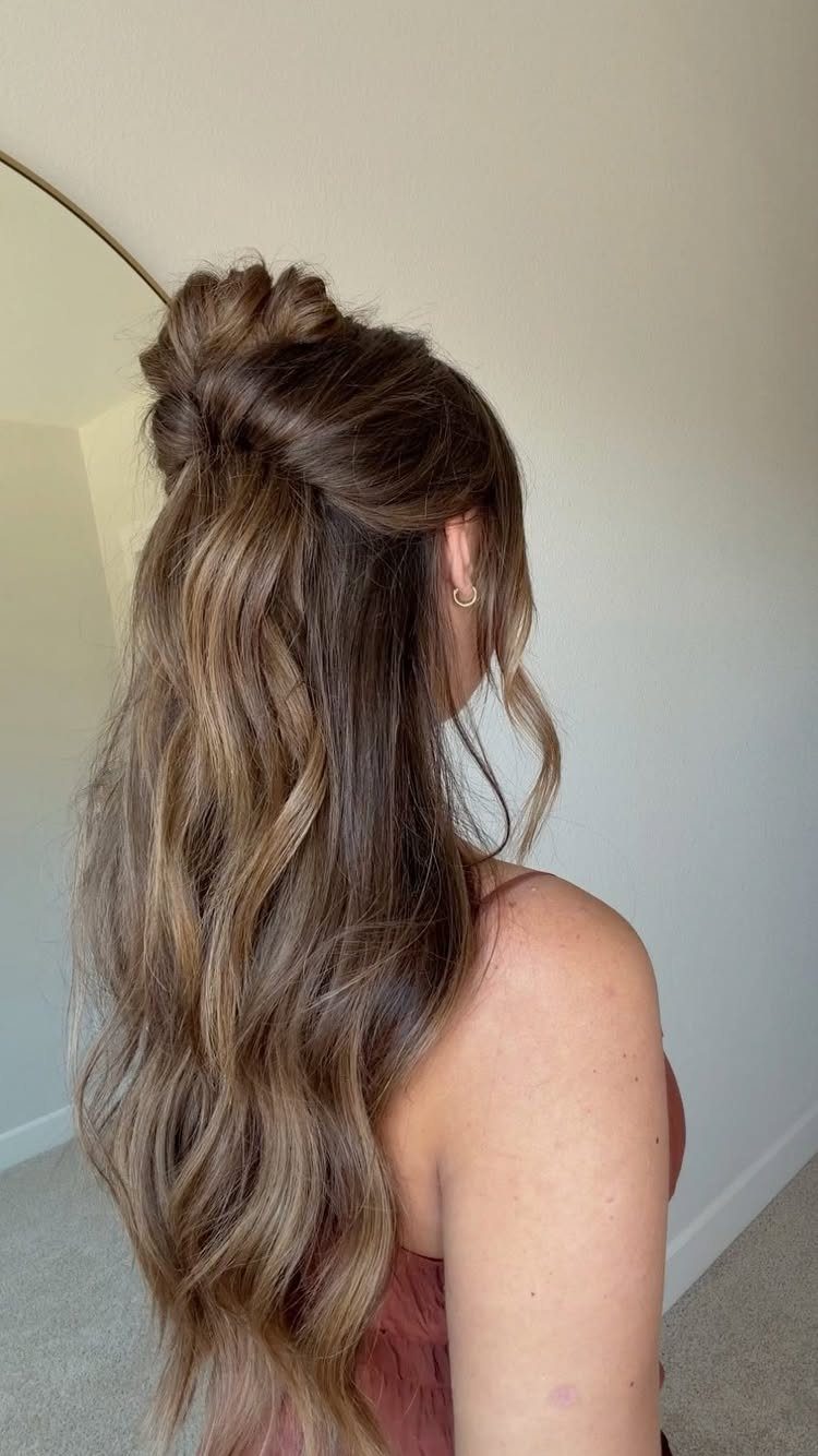 Woman showing long brown half-up hair with loose cascading waves