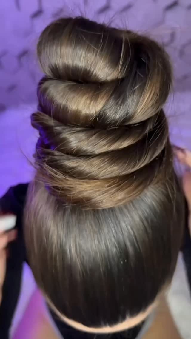 Long brown hair arranged in a polished layered twisted wedding updo