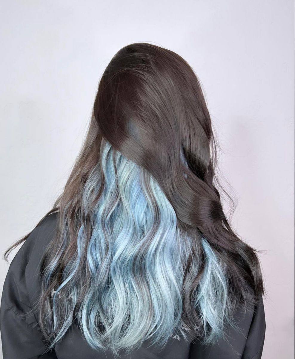 Brunette wavy hair reveals pale blue-gray and teal underlayers